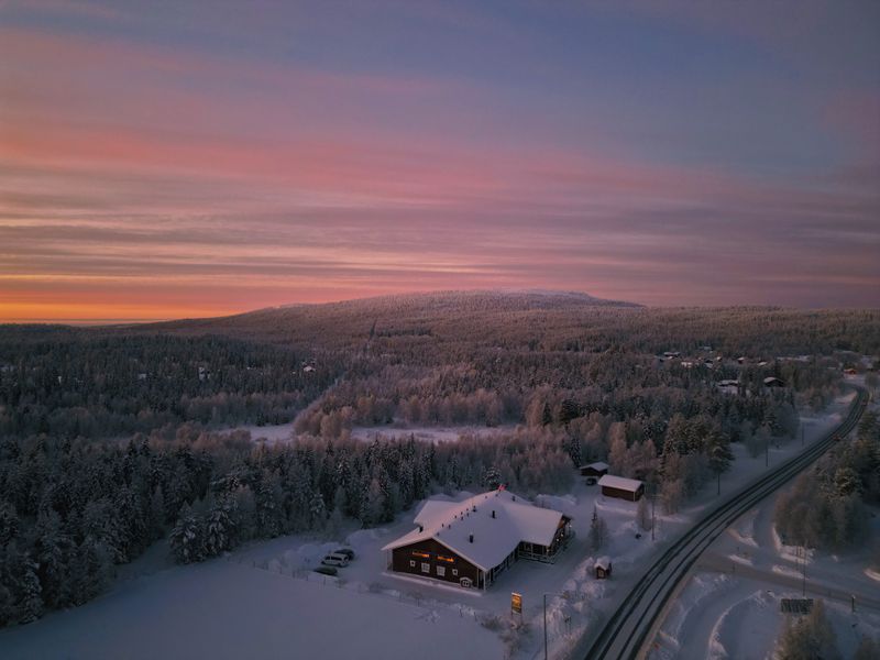 Vedere aeriană a unui sat din Laponia Finlandeză în timpul iernii cu case acoperite de zăpadă