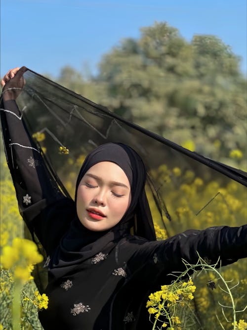 Portrait of Woman in Black Hijab and with Veil on Meadow