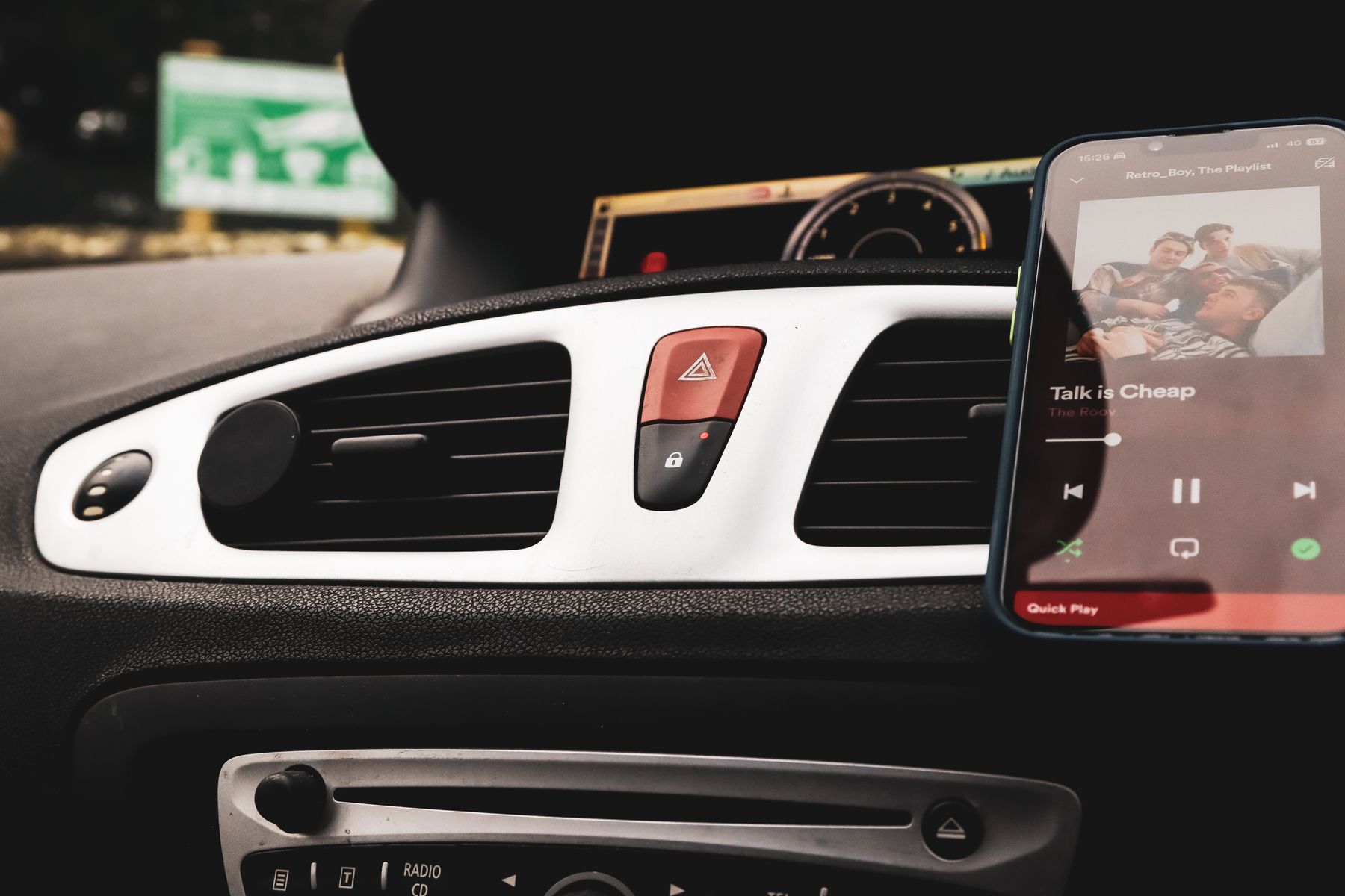 Smartphone mounted beside modern vehicle dashboard controls