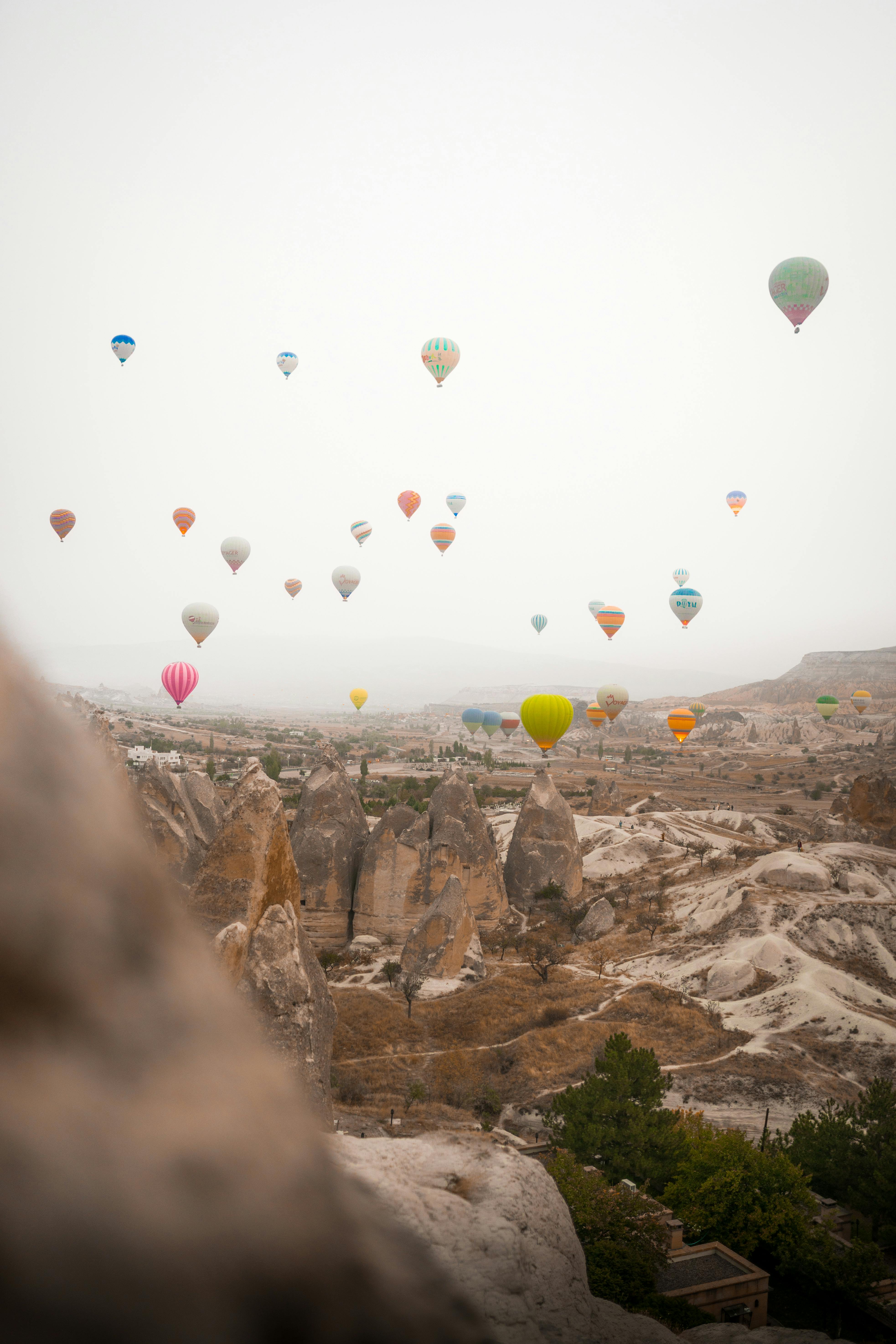 Scenic view of colorful hot air balloons soaring over Cappadocia's unique rock formations in Turkey.