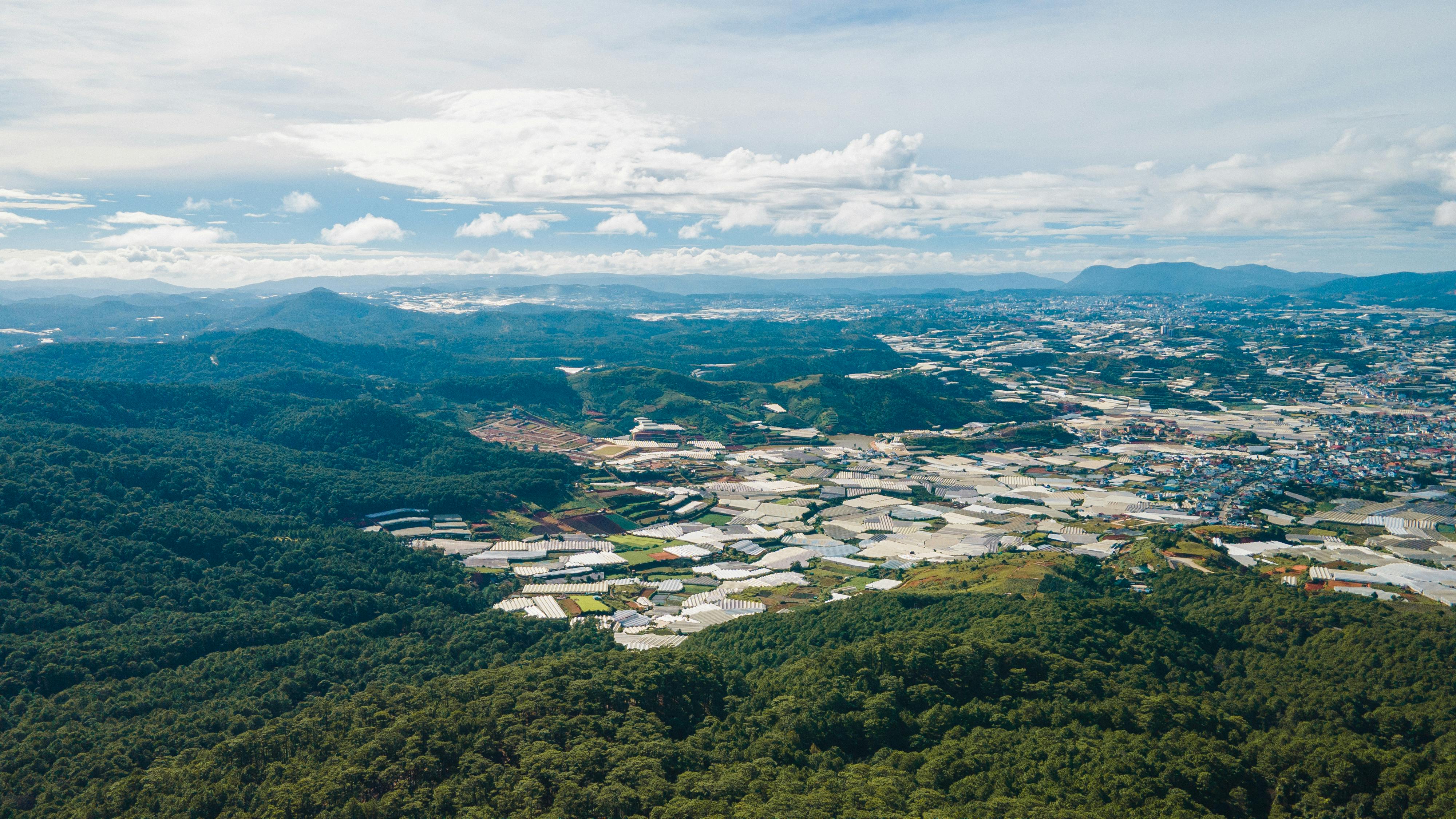 A breathtaking aerial view capturing the fields and forests of Đà Lạt, Vietnam on a summer day.