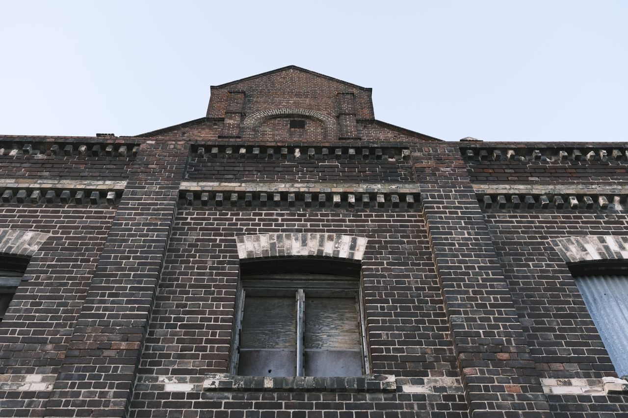 low angle shot of a vintage brick building facade showcasing architect