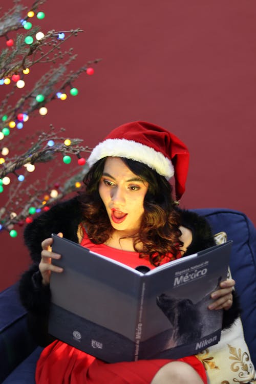 Woman in Santa Hat Sitting with Book