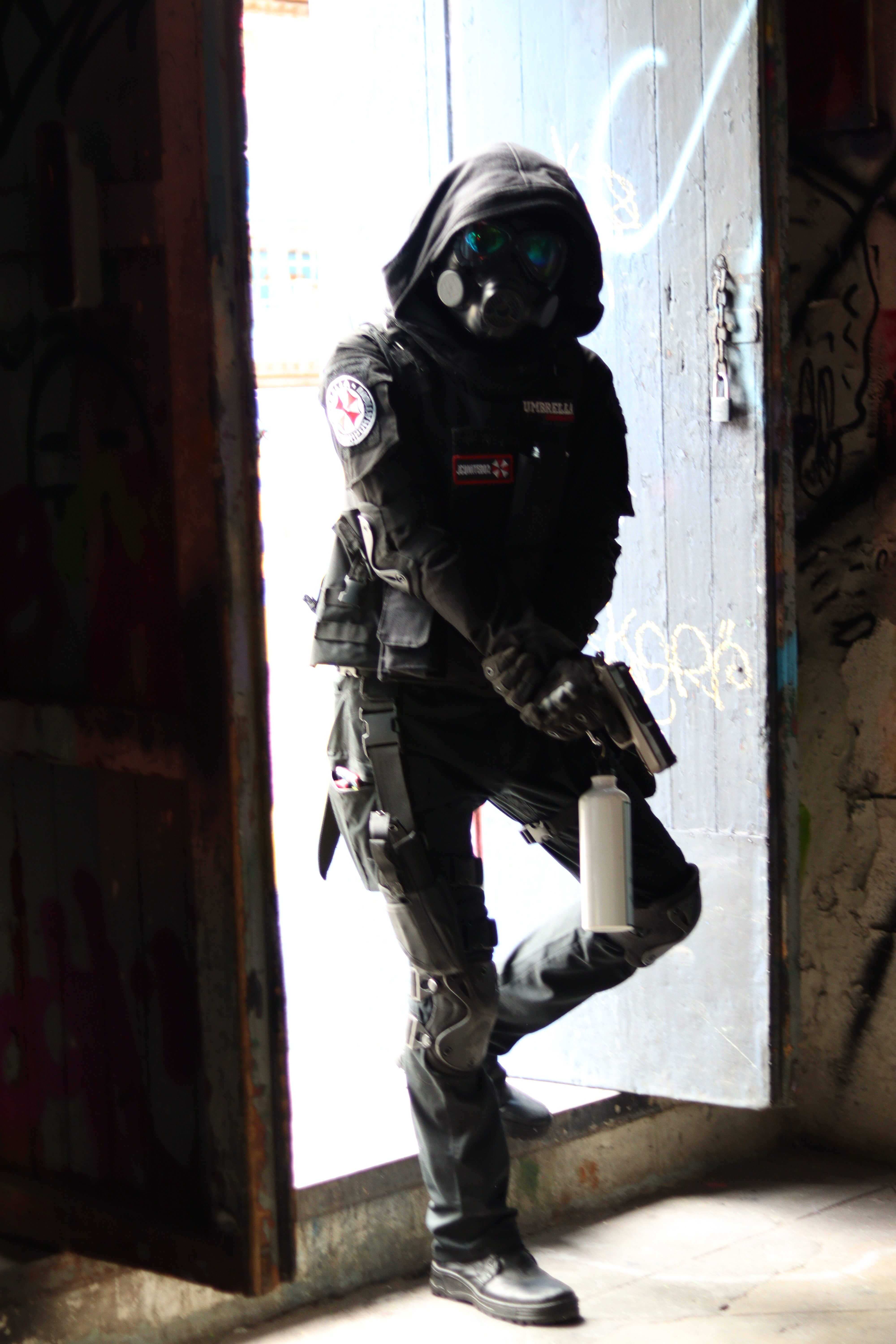 Person in tactical cosplay attire poses dramatically in a doorway, resembling a video game character.