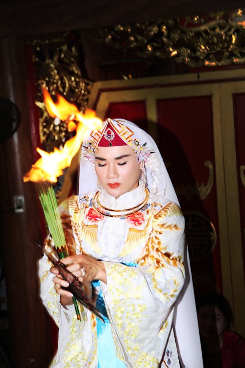 A woman in traditional costume holding a torch