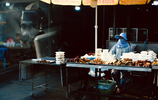 Asian woman selling diverse food at a night market stall. Authentic urban experience.