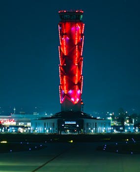 Illuminated control tower at Felipe Ángeles Airport in Zumpango, Mexico, featuring striking red lights against night sky.