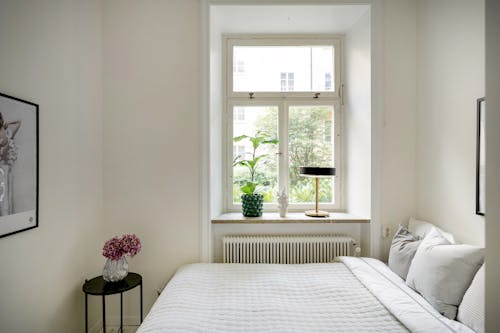 Free A white bed sitting in a small bedroom Stock Photo