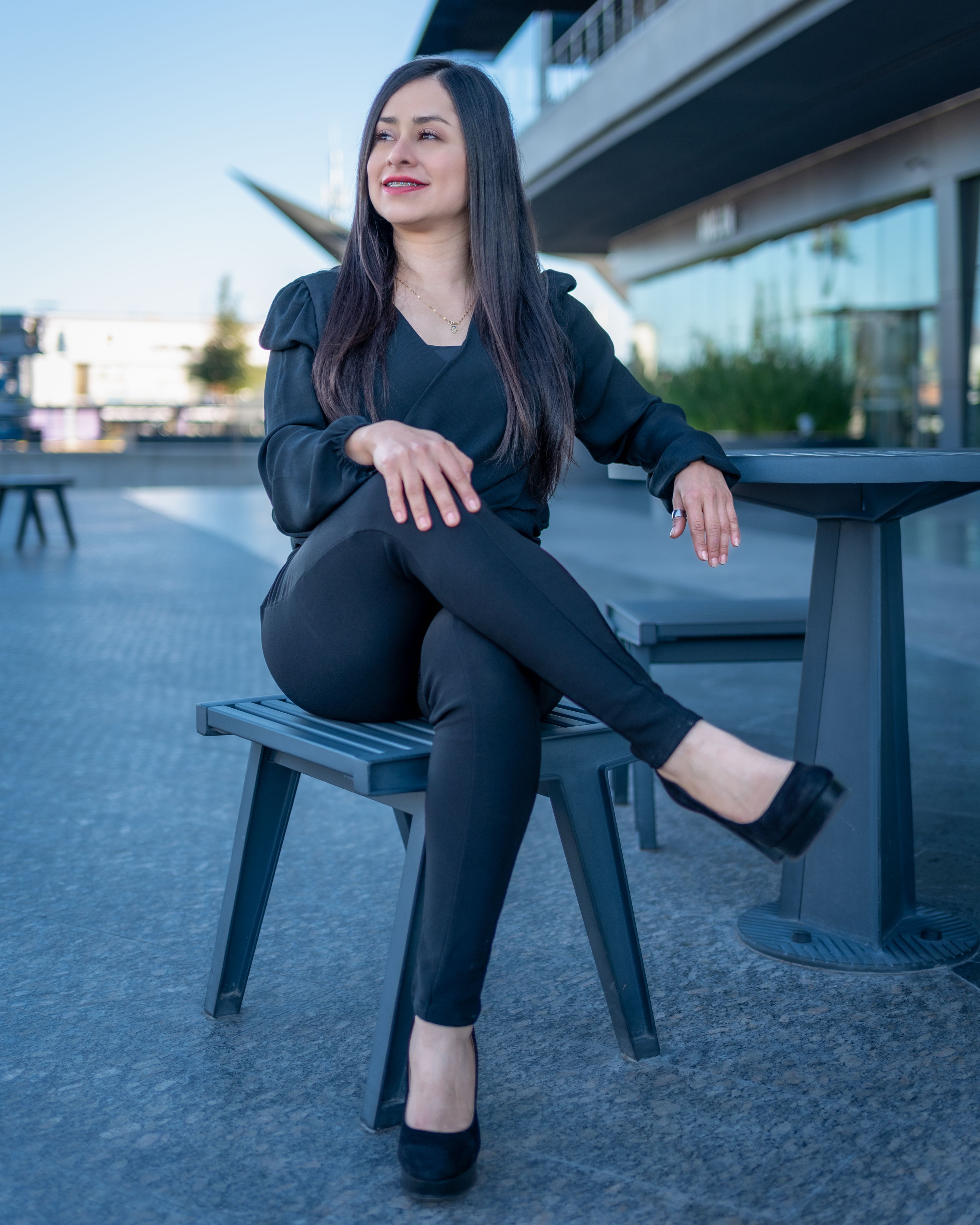 A woman in black pants sitting on a bench · Free Stock Photo