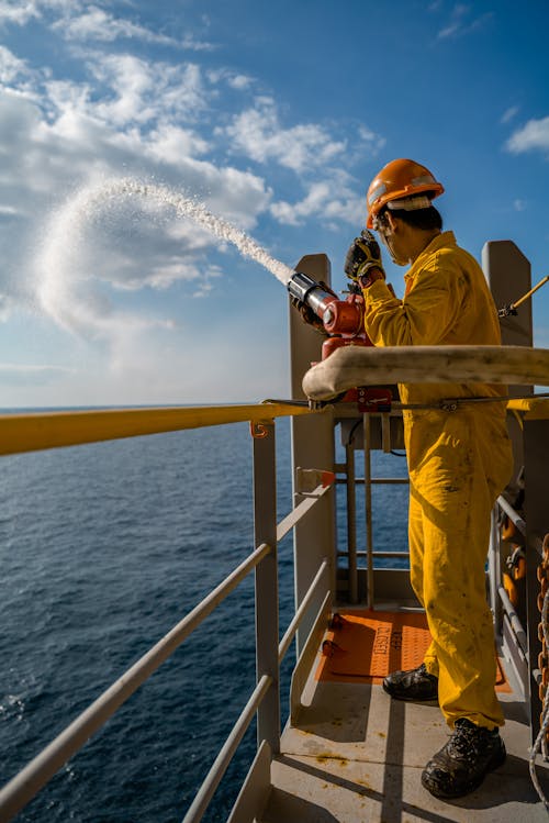 Worker with Water Gun on Vessel