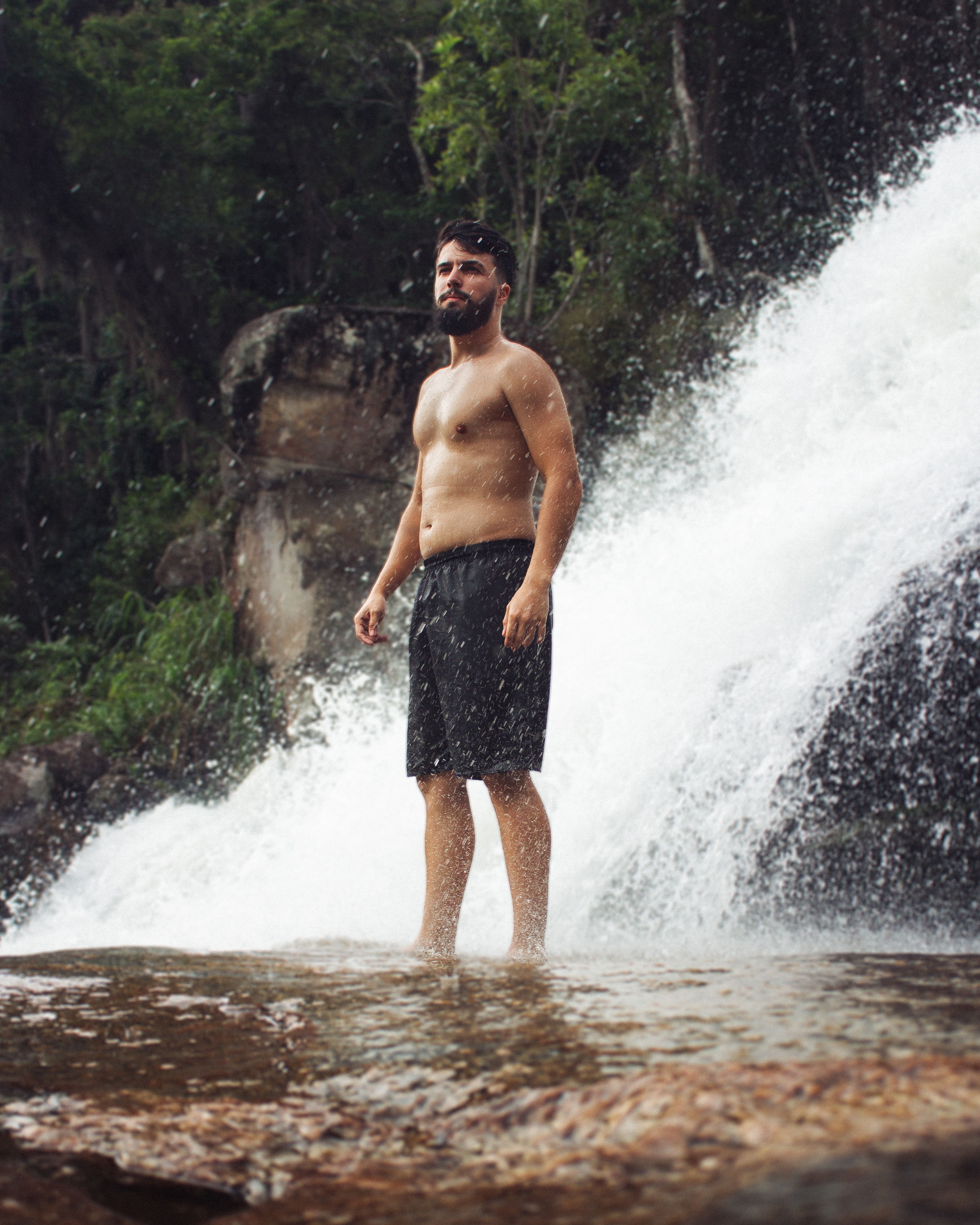 Man Standing by a Waterfall · Free Stock Photo