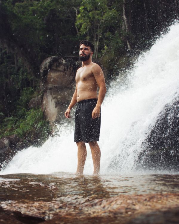 Man Standing by a Waterfall · Free Stock Photo