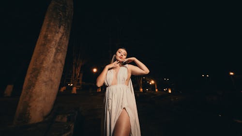 Woman Posing in White Dress at Night