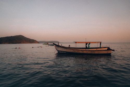 Free A serene view of a traditional boat at sunset, creating a tranquil oceanic atmosphere. Stock Photo