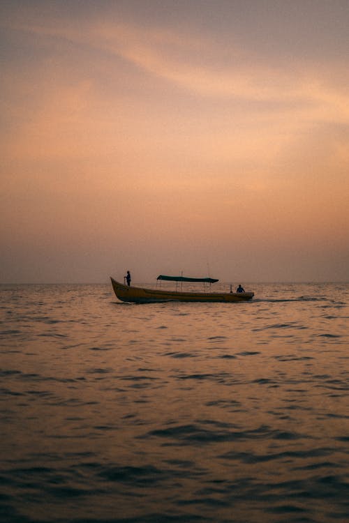 View of a Boat on a Body of Water at Sunset