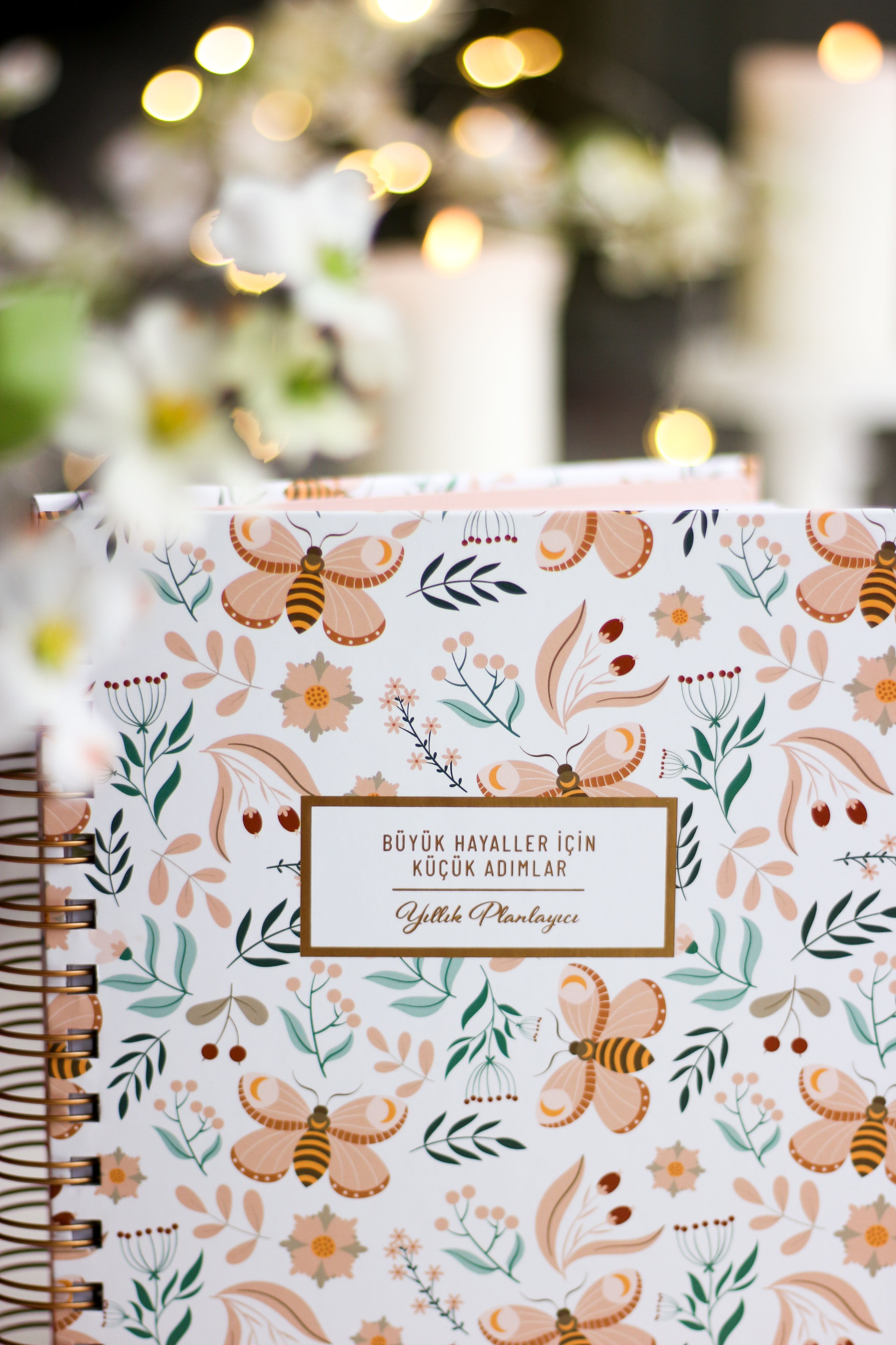 Vertical shot of a floral pattern planner with honeybee design and inspirational quote, perfect for organization.
