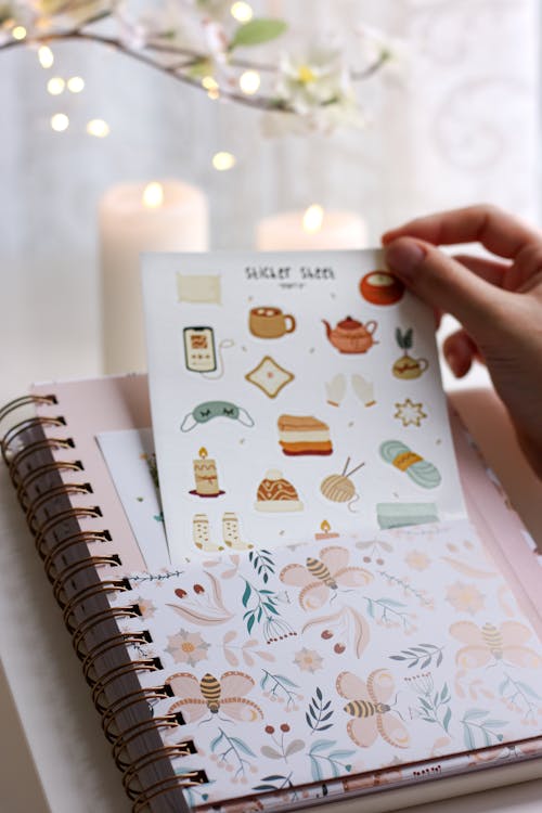 A person holding a planner with stickers on it · Free Stock Photo