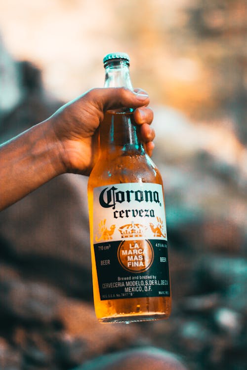 Free Person Holding Corona Cerveza Bottle Stock Photo