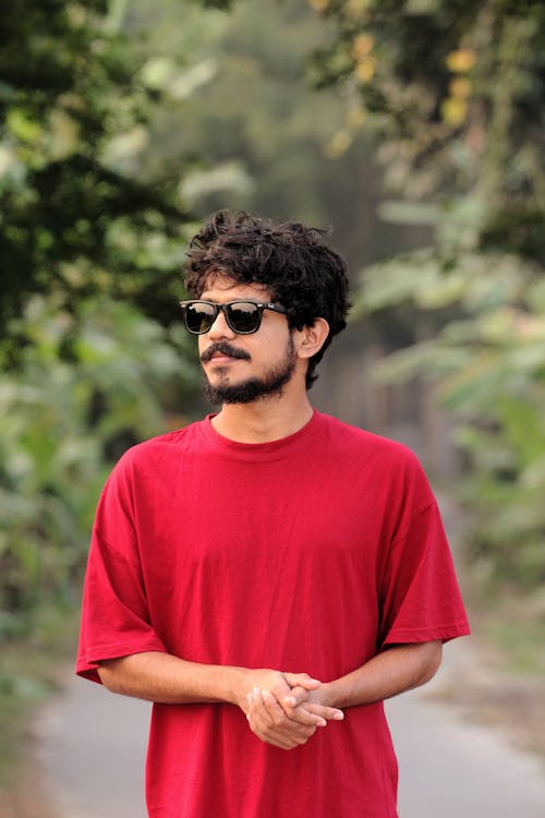 Bearded Man Wearing a Red T-shirt and Sunglasses Standing Outside 