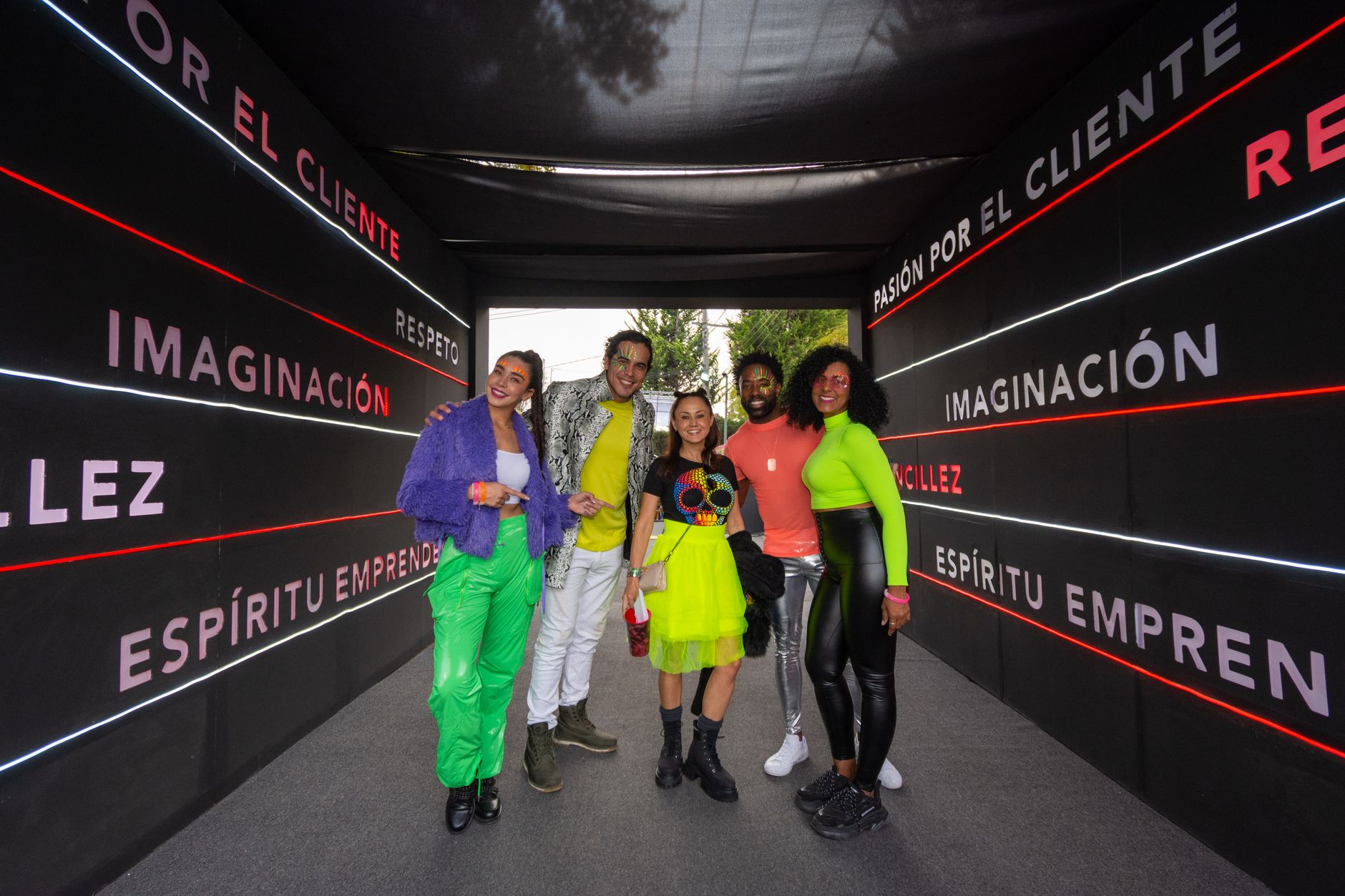 Vibrant group of friends posing in a creatively designed tunnel in Ciudad de México, showcasing colorful fashion.