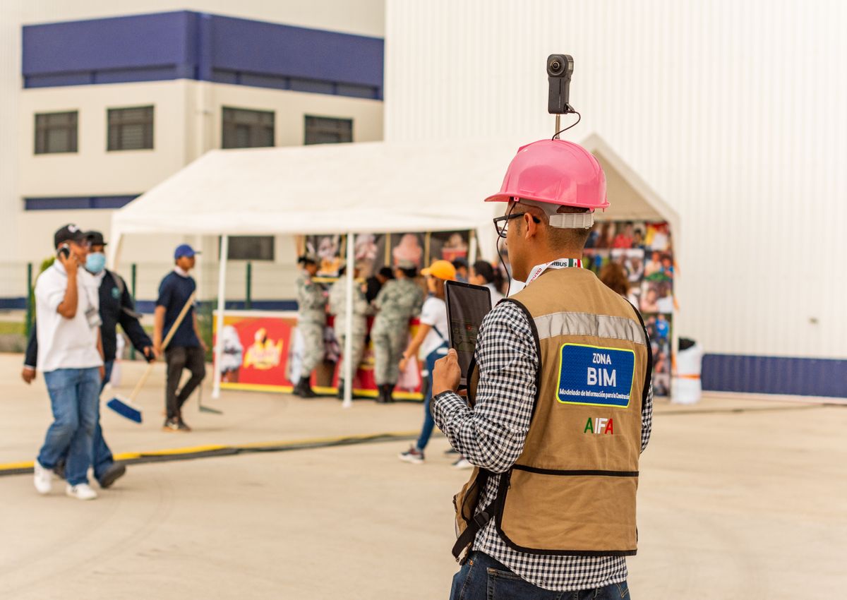 Field worker using a tablet and camera at an active job site