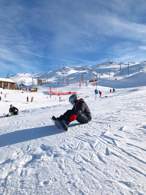 Free A snowboarder takes a break on a sunny winter day at a ski slope in Zermatt, Switzerland. Stock Photo