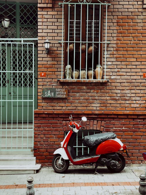 Motor Scooter Parked near Building Wall
