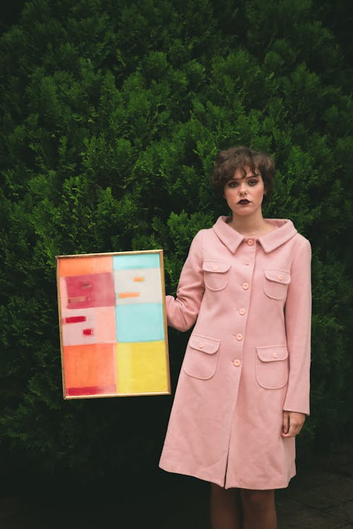 Free Woman Wearing Pink Button-up Coat Holding Photo Frame With Artwork Stock Photo