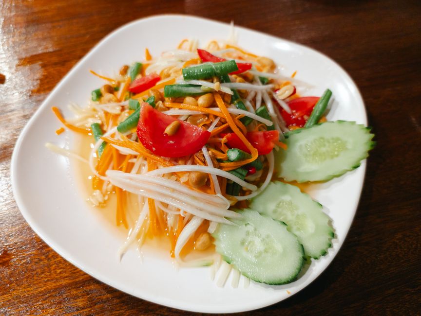 Shredded unripe papaya pounded with chile, lime, and fish sauce in a mortar and pestle.