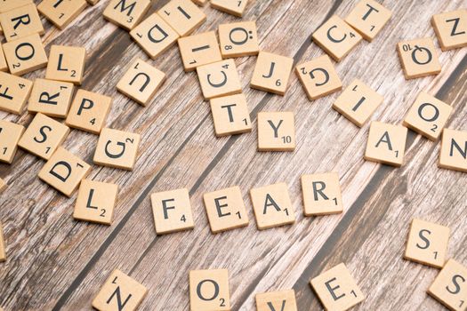 Scrabble letters spelling fear on a wooden table