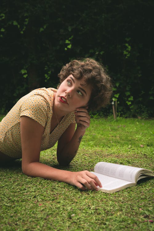 Free Woman Reading Book on Green Grass Stock Photo