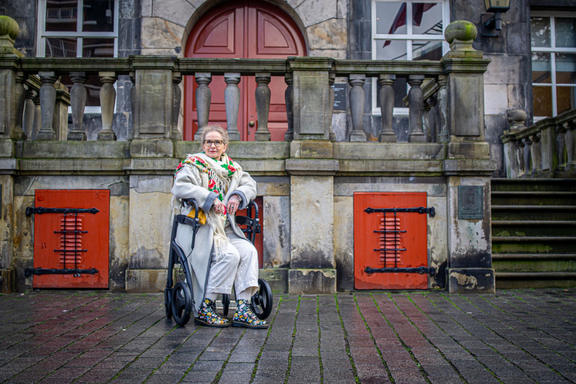 Woman in Coat Sitting on Walker