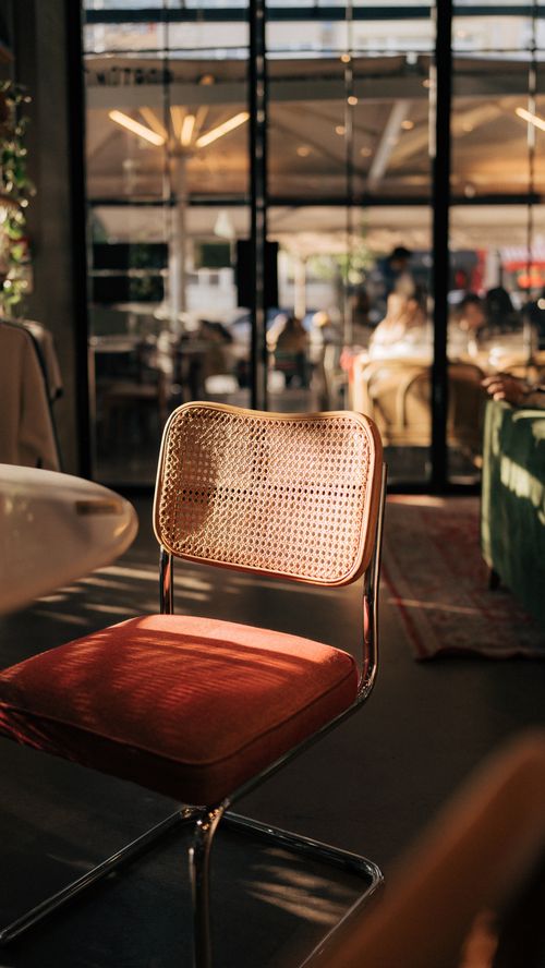 Free A rattan chair with a red cushion in a sunlit Istanbul restaurant. Stock Photo