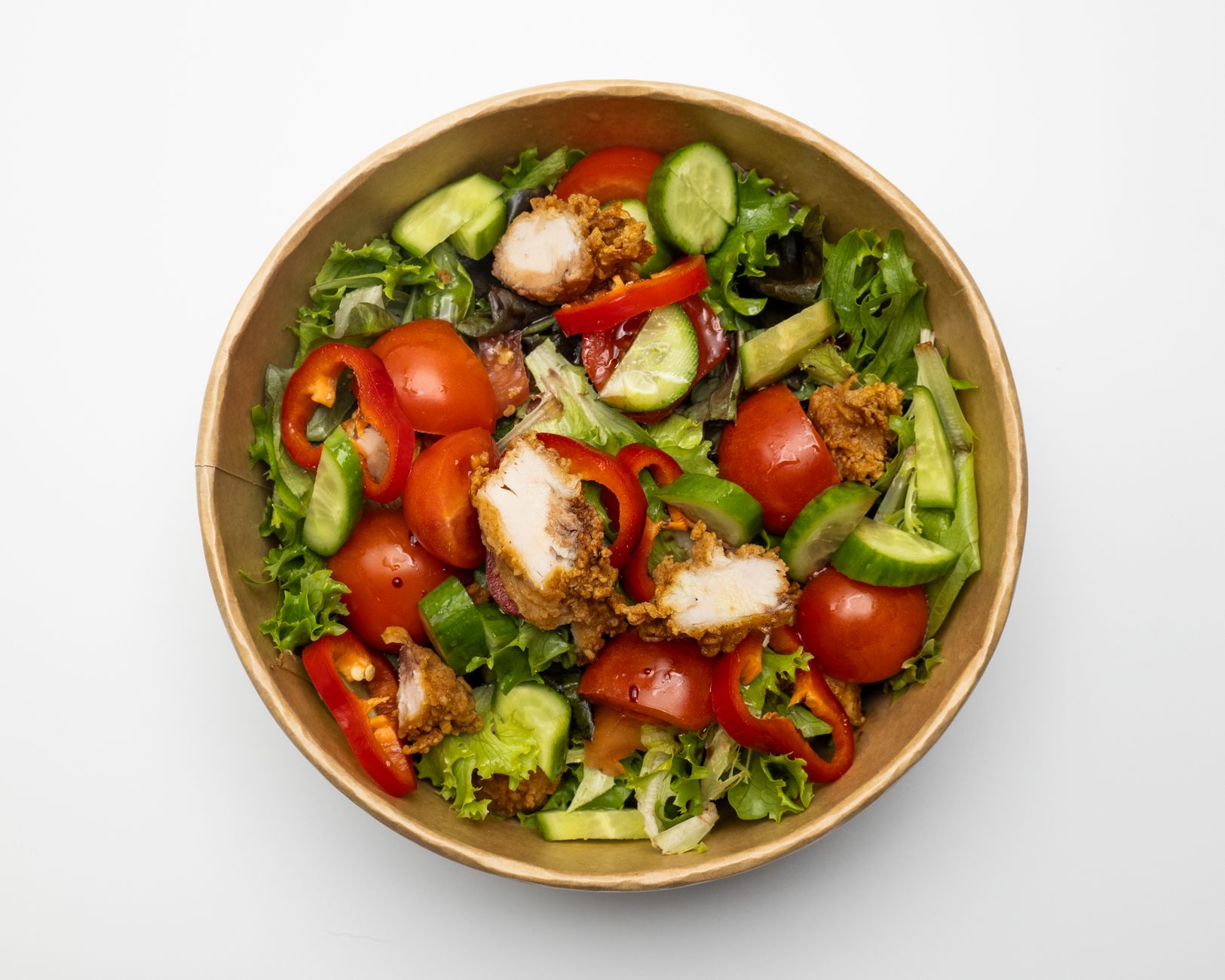 Delicious mixed salad with crispy chicken, fresh veggies in a bowl, perfect for a healthy meal.
