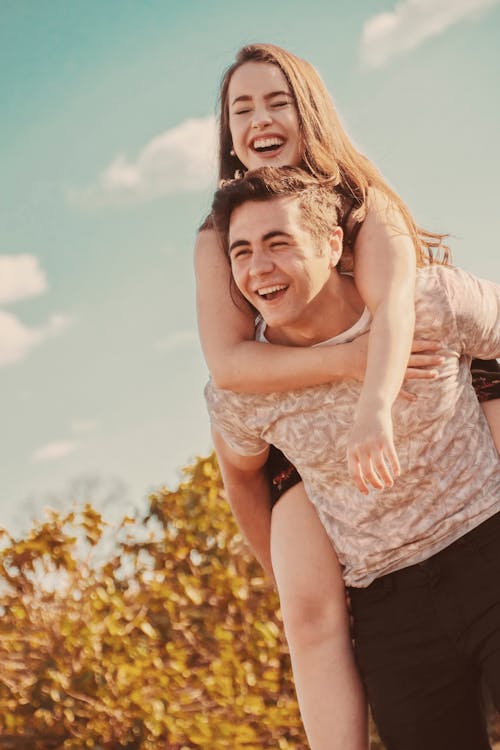 Man Giving Piggyback on Woman While Standing on Ground