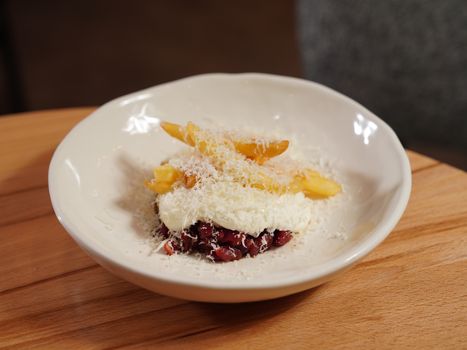 A close-up of french fries topped with grated cheese on a ceramic plate.
