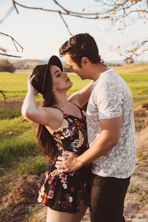 Man And Woman Standing Near Green Grass Field