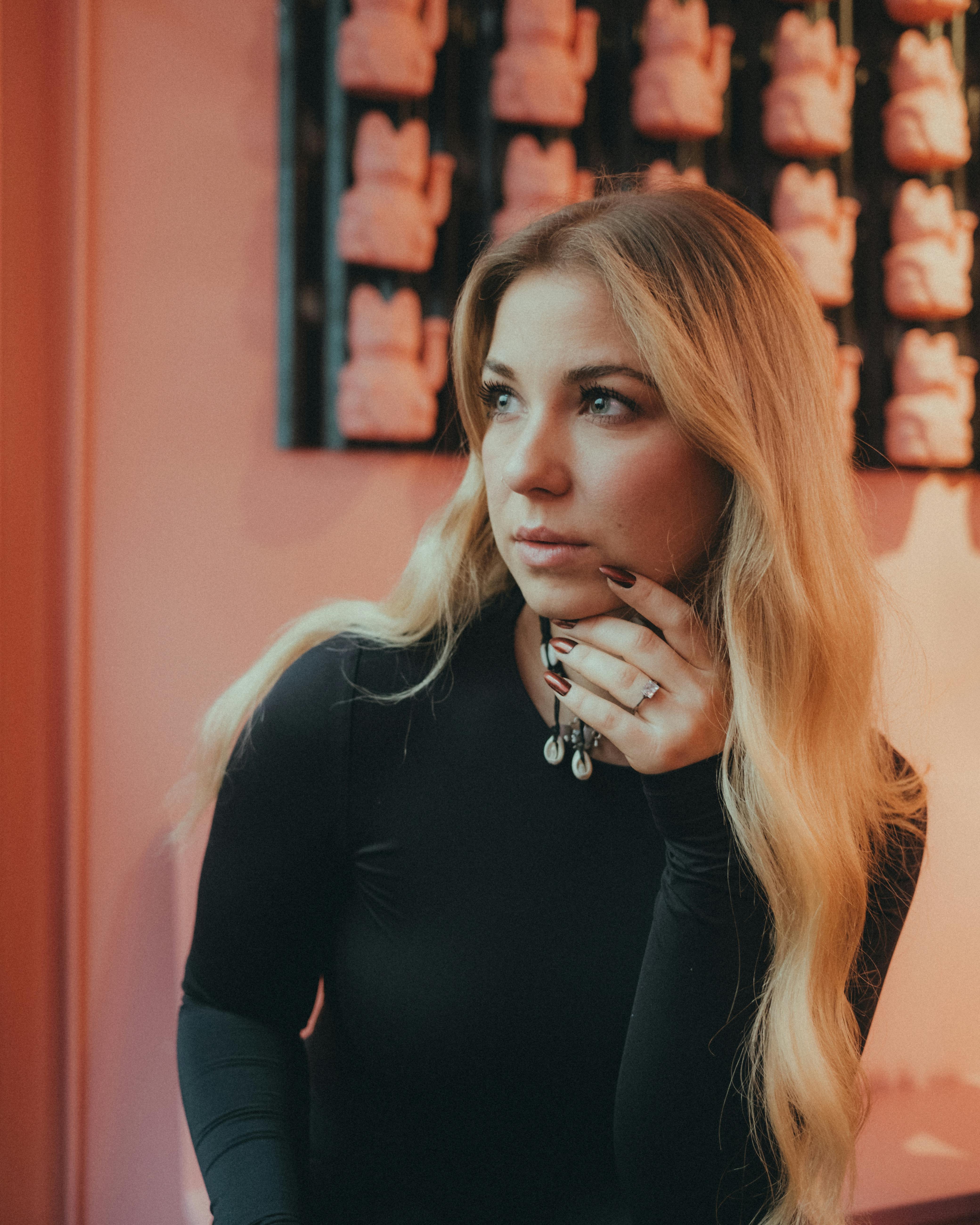 Thoughtful young woman with long blonde hair in Berlin's artistic setting.