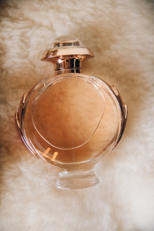 Close-up of a Bottle of Perfume Lying on Soft Fabric 