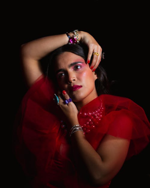 Model in Red Chiffon Dress Embracing Her Head