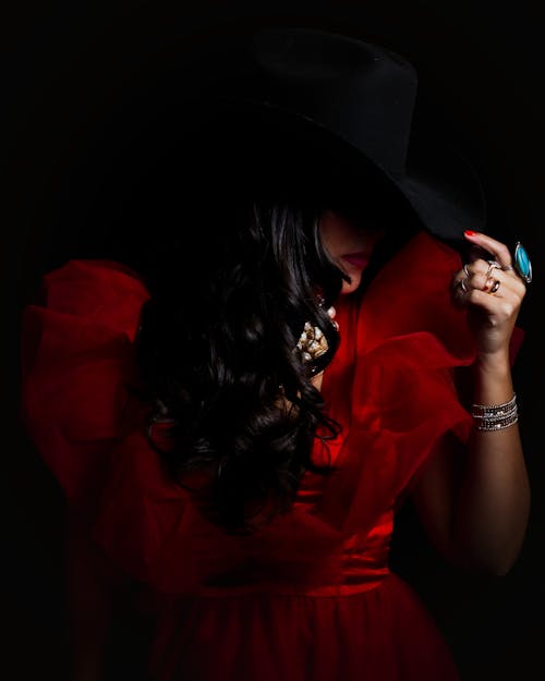 A woman in a red dress and cowboy hat