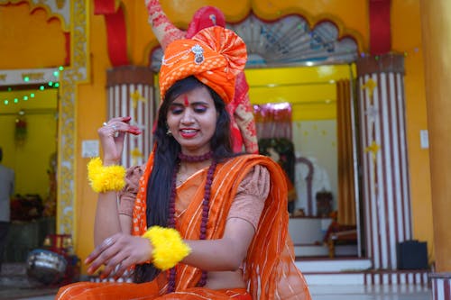 Woman in Traditional Clothing Sitting on Steps in front of a Temple 