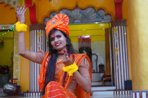 Woman in Traditional Clothing Sitting on Steps in front of a Temple 