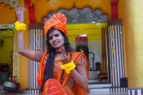 Free A young Indian woman in traditional attire poses cheerfully at a temple. Stock Photo