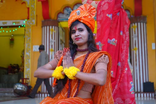 Woman in Traditional Clothing Sitting on Steps in front of a Temple 