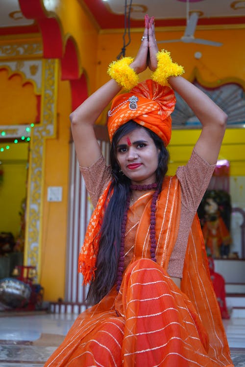 Woman in Traditional Clothing Sitting on Steps in front of a Temple 