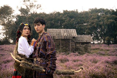 Young Couple in Traditional Clothing Standing on a Meadow 