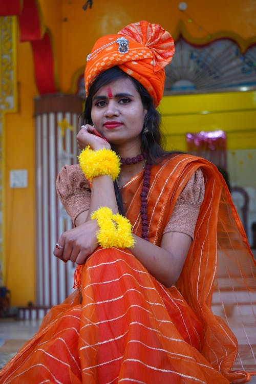 Woman in Traditional Clothing Sitting on Steps in front of a Temple 