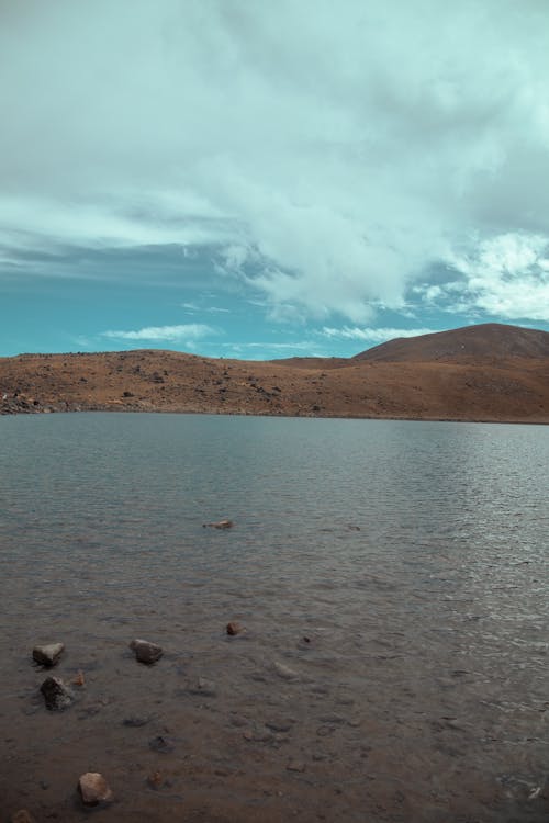 Foto profissional grátis de água, céu, colinas