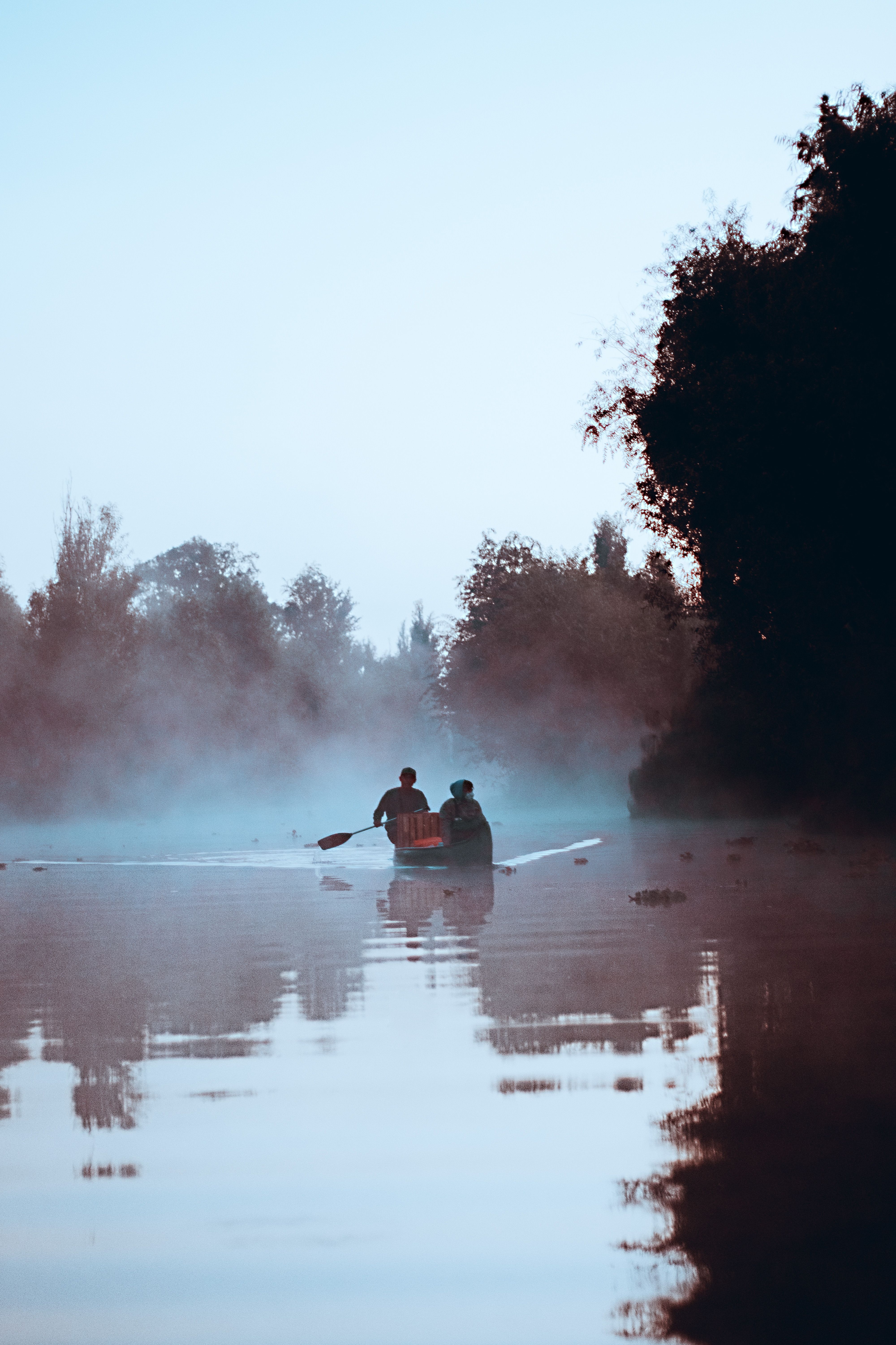 Woman and man on a boat on a river in a forest